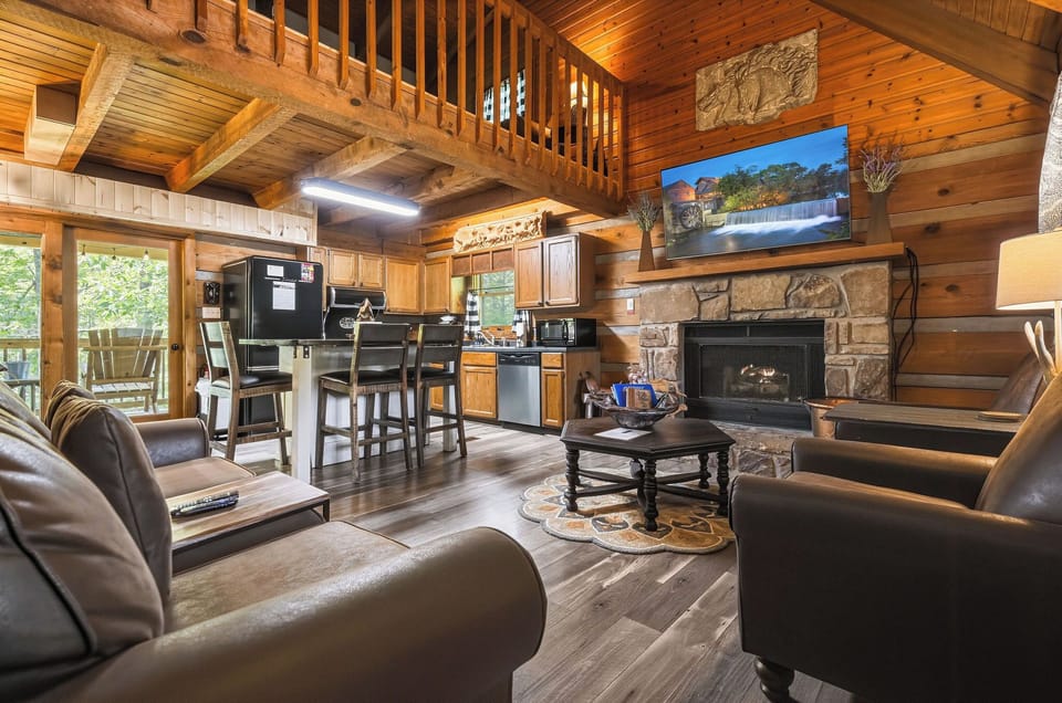 Relax in your spacious cabin with vaulted wood ceilings, a cozy stone fireplace, modern kitchen, and plush seating—perfect for unwinding after exploring the mountains.