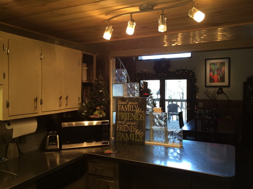 Kitchen with view to dining / living room & outside deck with wooded view