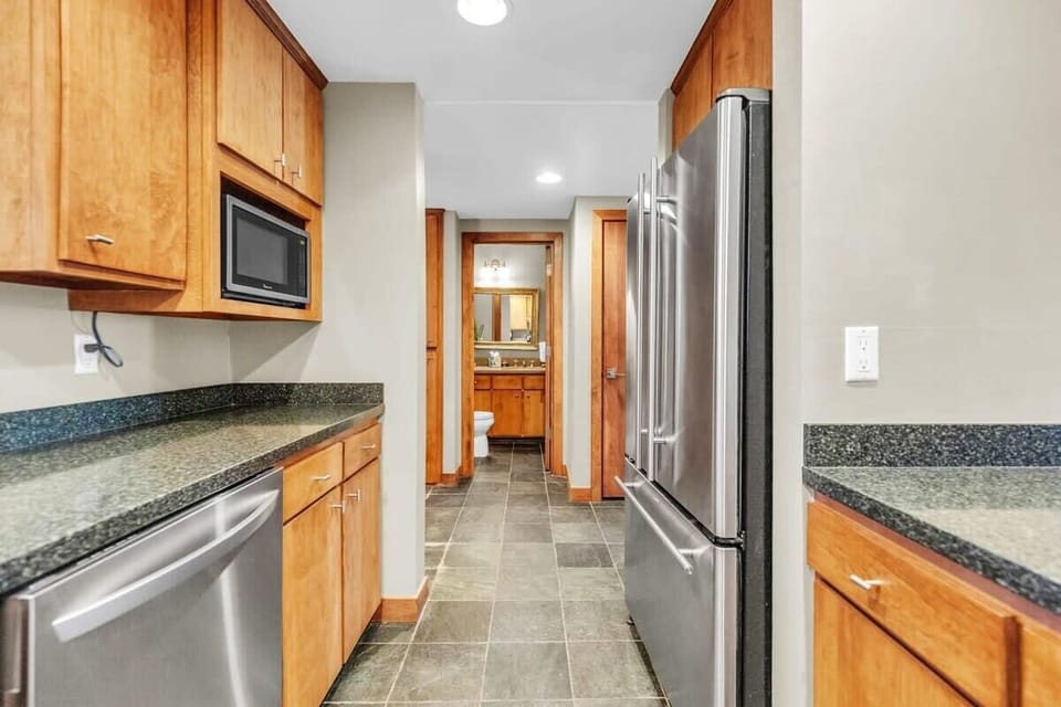 The view from the kitchen towards the half-bathroom which is located across the tiled hallway.