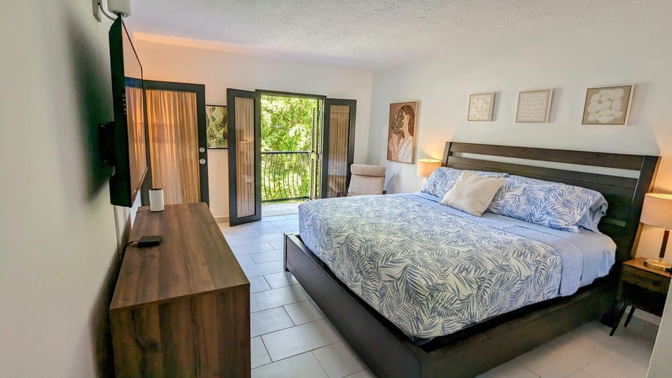 Master bedroom with king size bed and private balcony opening onto patio