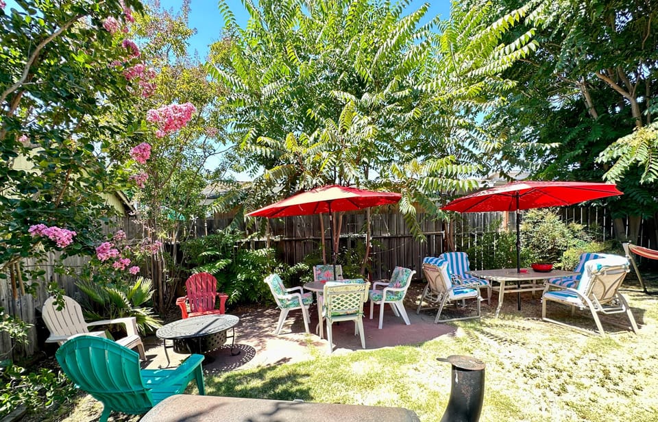 Private-backyard-patio-outdoor-seating-barbecue pit-umbrellas-garden-lounge-area
