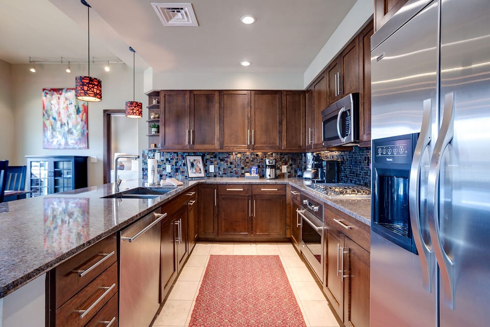 Your gourmet kitchen awaits with granite countertops, stainless steel appliances, and elegant dark wood cabinetry for memorable meal preparation.
