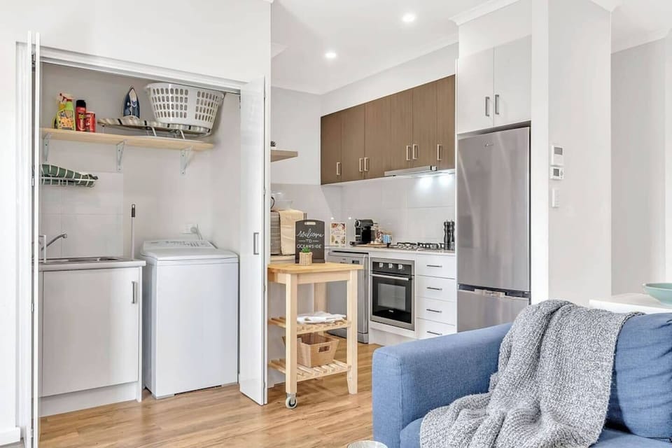 A laundry cupboard includes a washing machine, dryer and basin. 

