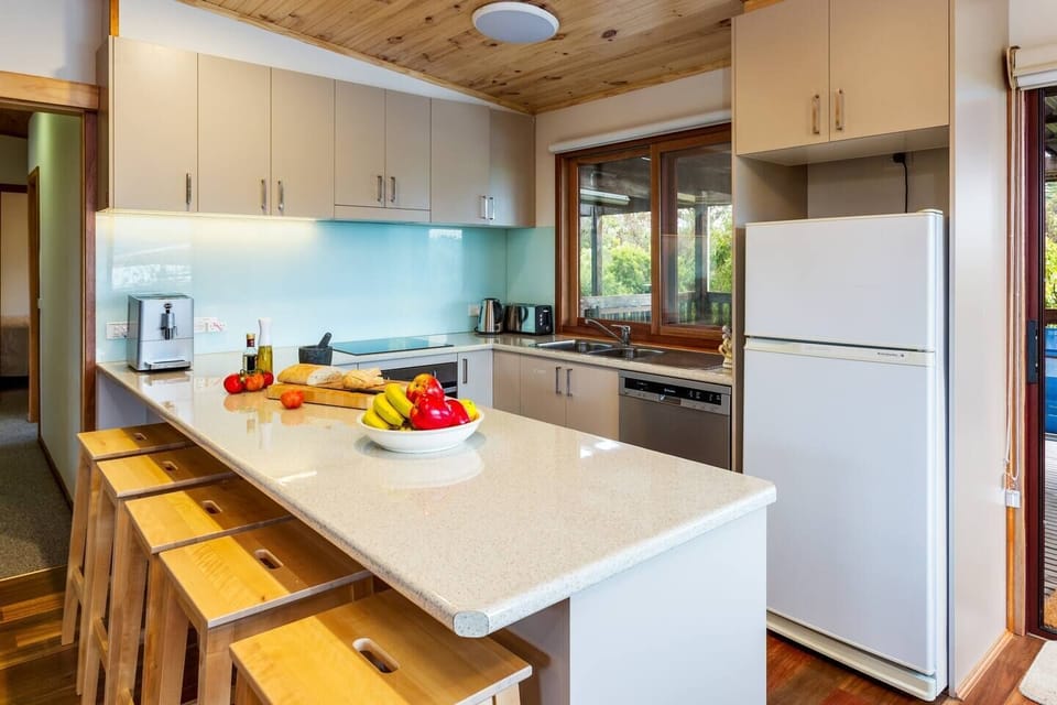 The kitchen offers plenty of bench space to prepare meals, with stools to pull up for a quick bite to eat or chats with chef.