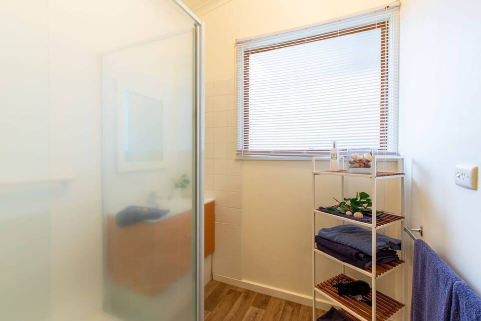 The bath features timber floors and walk-shower and floating vanity, plus a separate toilet, providing convenience for groups. 