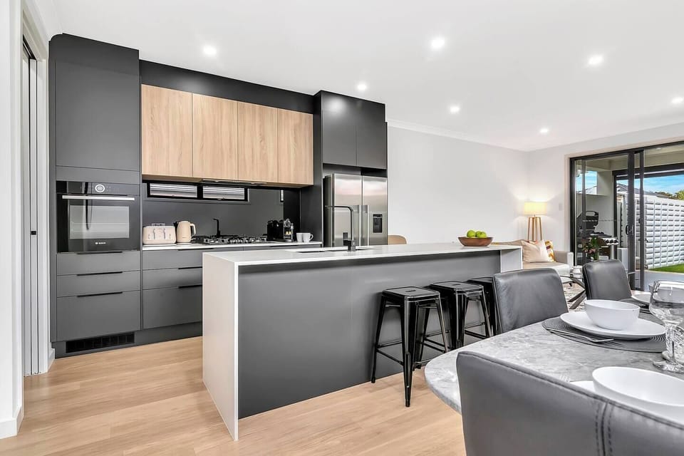 A modern, streamlined kitchen has all the essentials needed to cook your meals at home, with casual seating available at the breakfast bar. 
