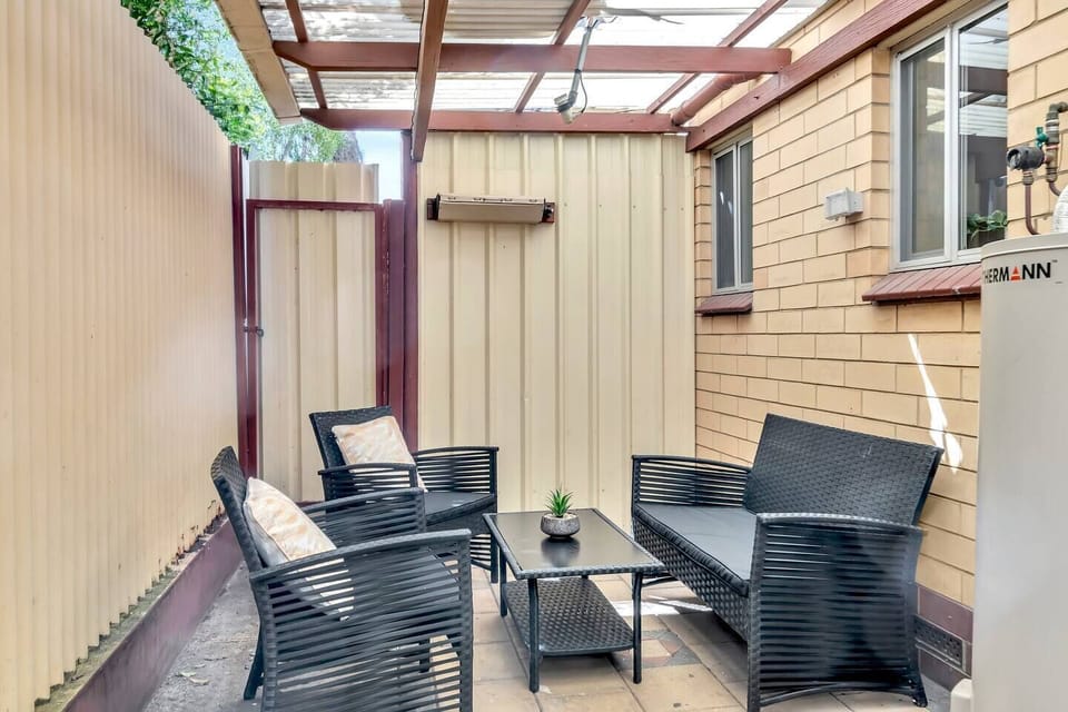 A private patio at the rear of the home includes a relaxed outdoor setting, providing an ideal spot to enjoy an alfresco lunch or peaceful morning cuppa.
