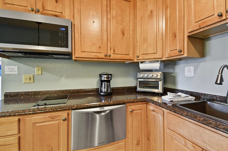 Well-appointed kitchen featuring dishwasher, cooktop, microwave, and essential appliances for convenient in-home dining.
