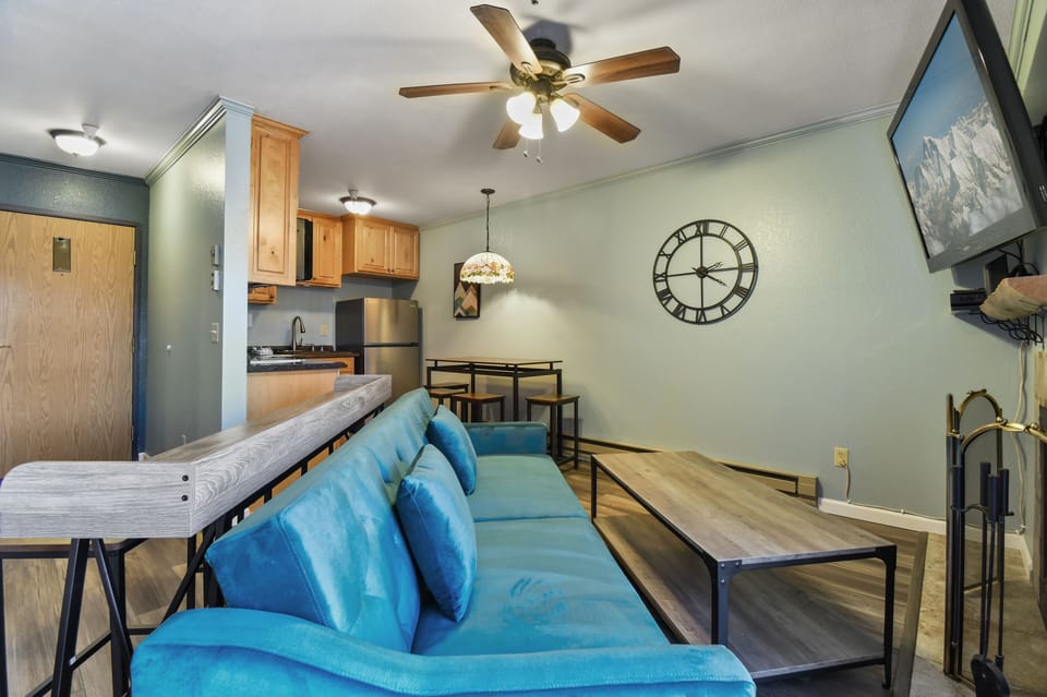 Comfortable living area with sofa seating, coffee table, and open sightlines to the dining space and kitchenette.