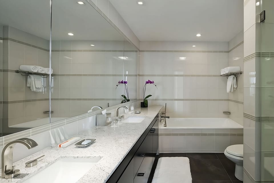 Refresh with a long vanity, bright lighting, and deep tub.