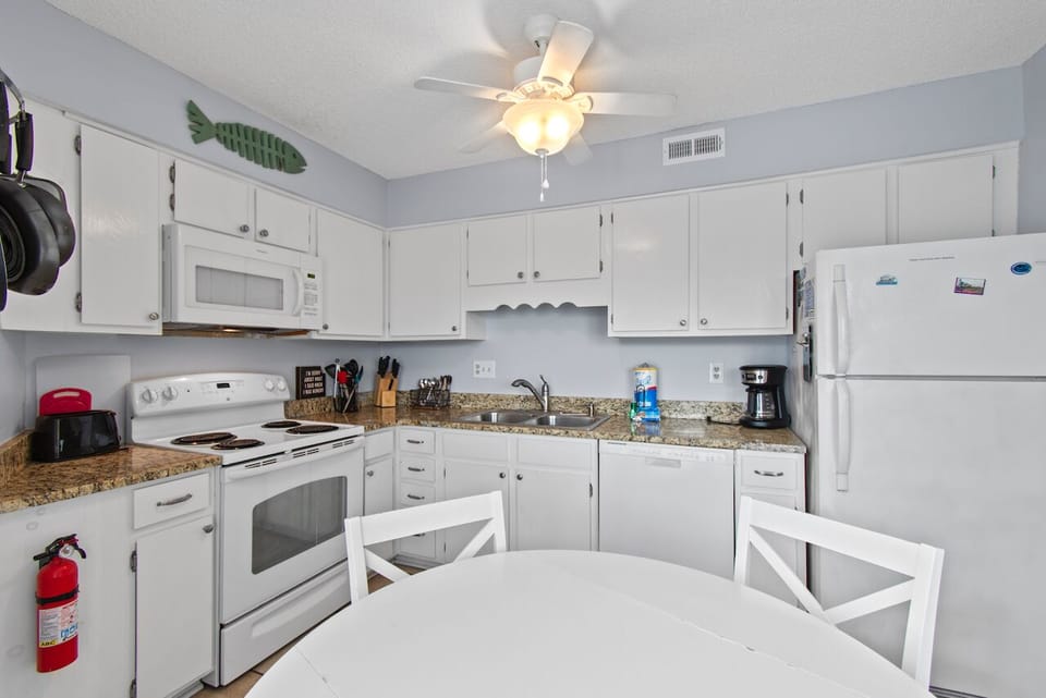 Cook your favorite meals in this fully-equipped kitchen with granite counters, modern appliances, and coastal charm.