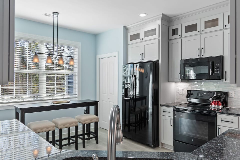 Your spacious kitchen awaits with modern appliances, granite counters, and a breakfast bar perfect for morning coffee.