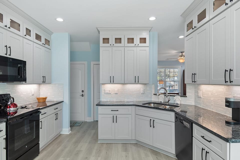 Your gourmet kitchen awaits with gleaming granite countertops, pristine white cabinetry, and modern appliances ready for memorable meal preparation.
