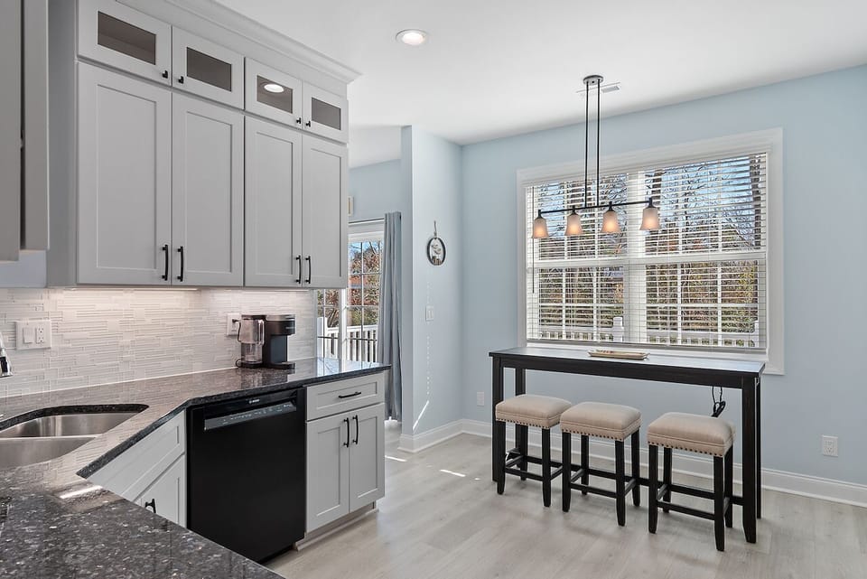 Your modern kitchen features sleek white cabinets, granite counters, and a breakfast bar where you can sip morning coffee while sunlight streams through.