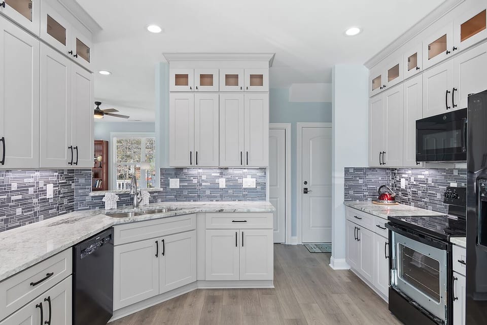 Your gourmet kitchen features white cabinets, marble counters, and modern appliances - perfect for creating memorable meals during your stay.