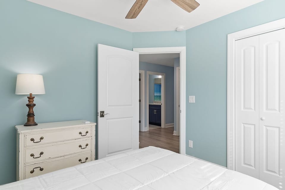 Relax in your peaceful retreat with calming mint walls, rustic beams overhead, and classic furnishings that create the perfect coastal sanctuary.