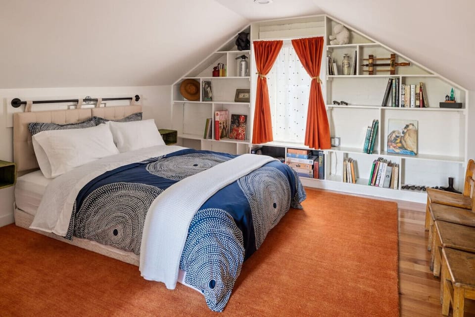 Cozy attic bedroom with curated shelves, inviting textiles, and a warm ambiance—perfect for a restful night's sleep.