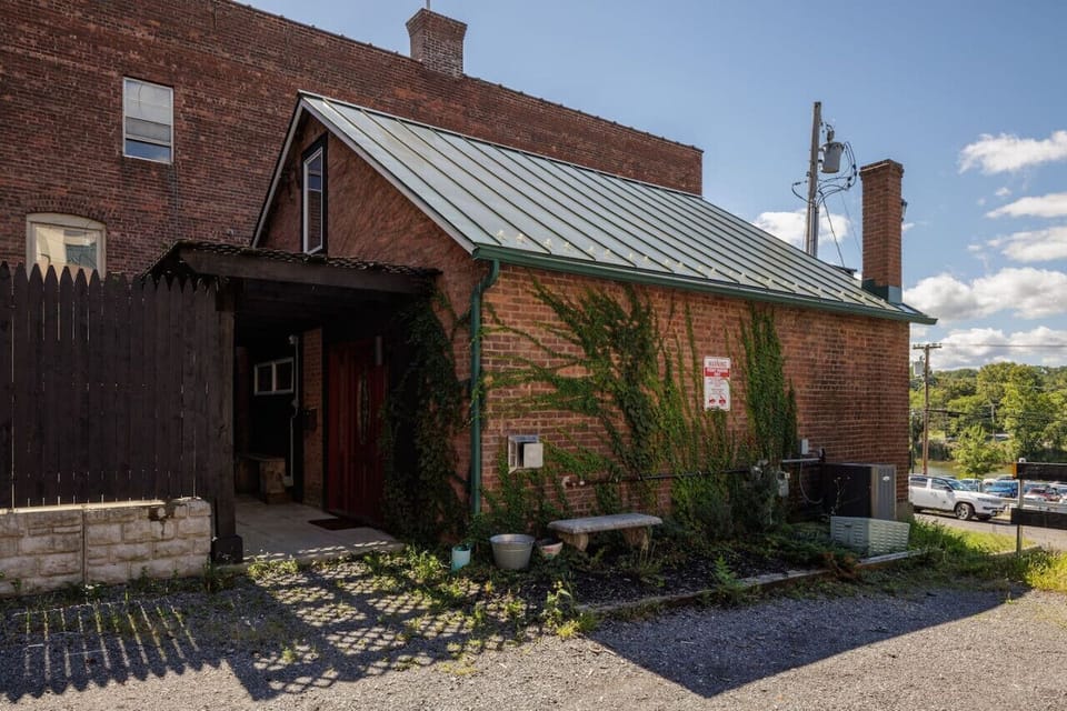Welcome to the Catskill Cottage! This charming brick exterior offers a cozy, tucked-away feel while being just steps from Main Street.