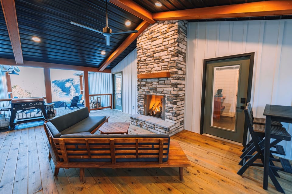 “The Breezeway” - A special result of the unique split layout of this cabin, the breezeway provides access to two private bedroom and bathroom suites, and features comfortable seating in front of the outdoor fireplace! 