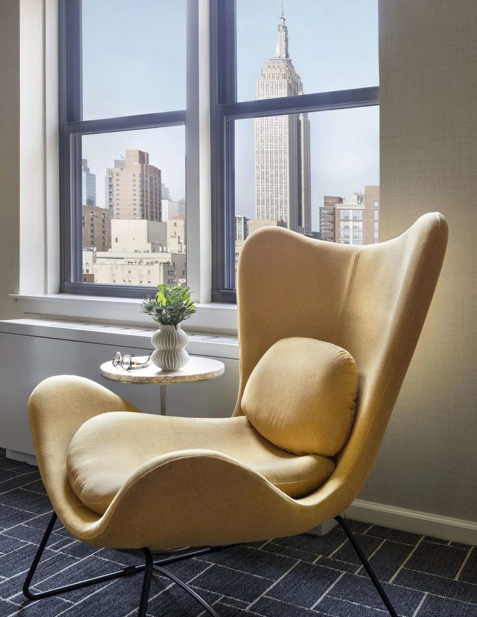 Sink into the statement chair and savor iconic city views.