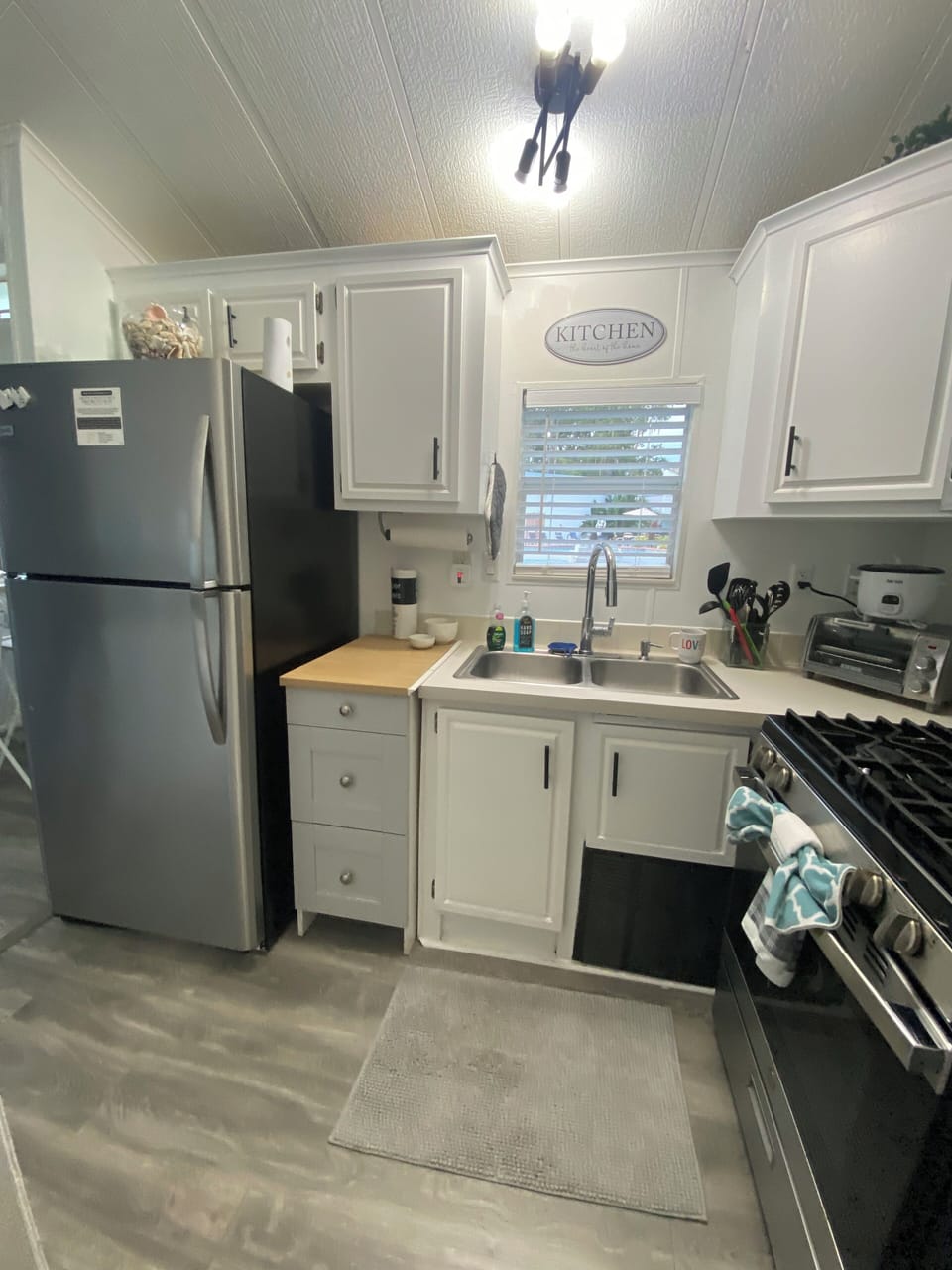 Light and bright freshly painted kitchen cabinets and new flooring.
