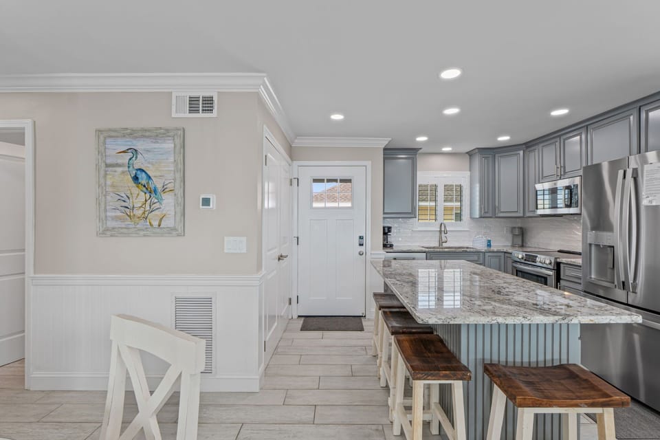 Your bright coastal kitchen features granite countertops, stainless appliances, and an island with seating for memorable meals together.