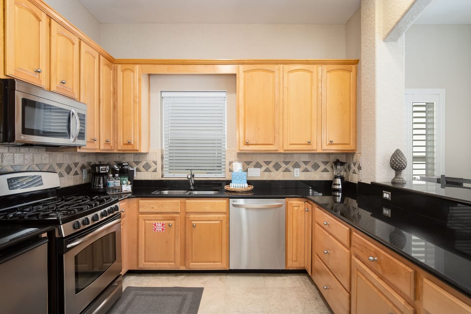 Your fully equipped kitchen features warm wood cabinets, sleek black granite counters, and stainless steel appliances for all your cooking needs.