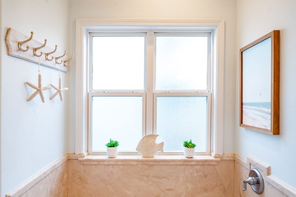After a day in the sand and sun, unwind in the deep soaking tub with fresh towels and calming coastal touches.