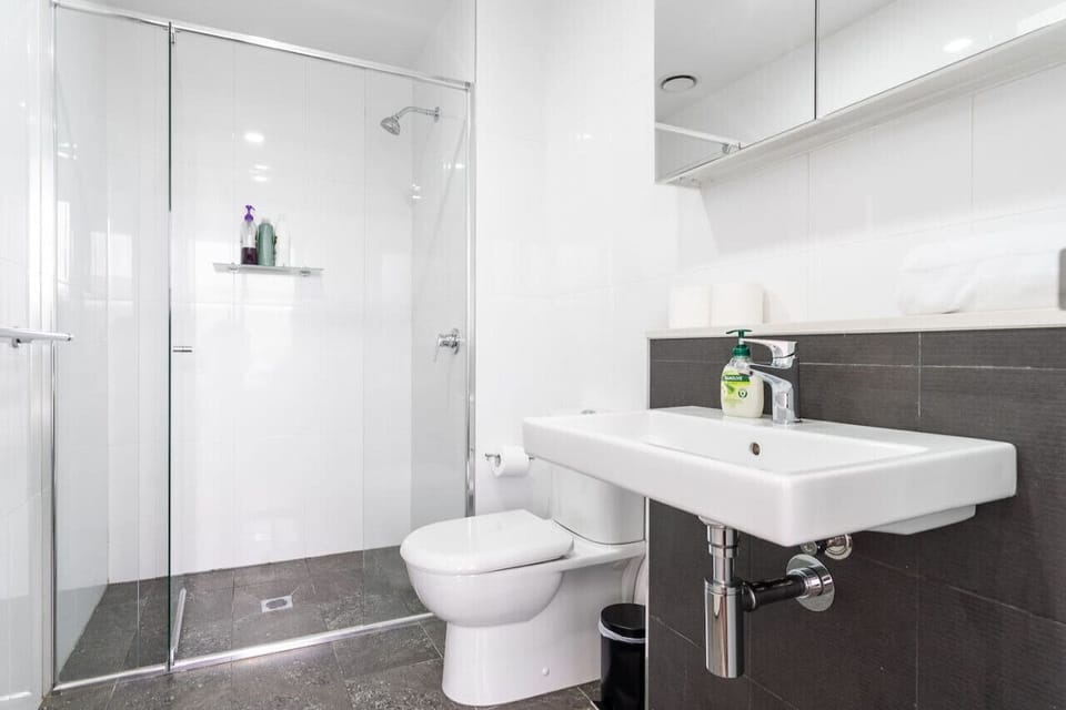 Unwind in a modern bathroom that features a clean, minimalist shower for a refreshing and stylish experience.