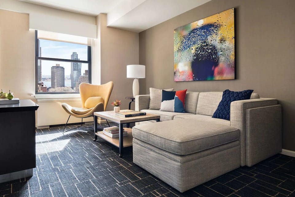 Relax on the spacious sectional with sunlight and skyline backdrop.