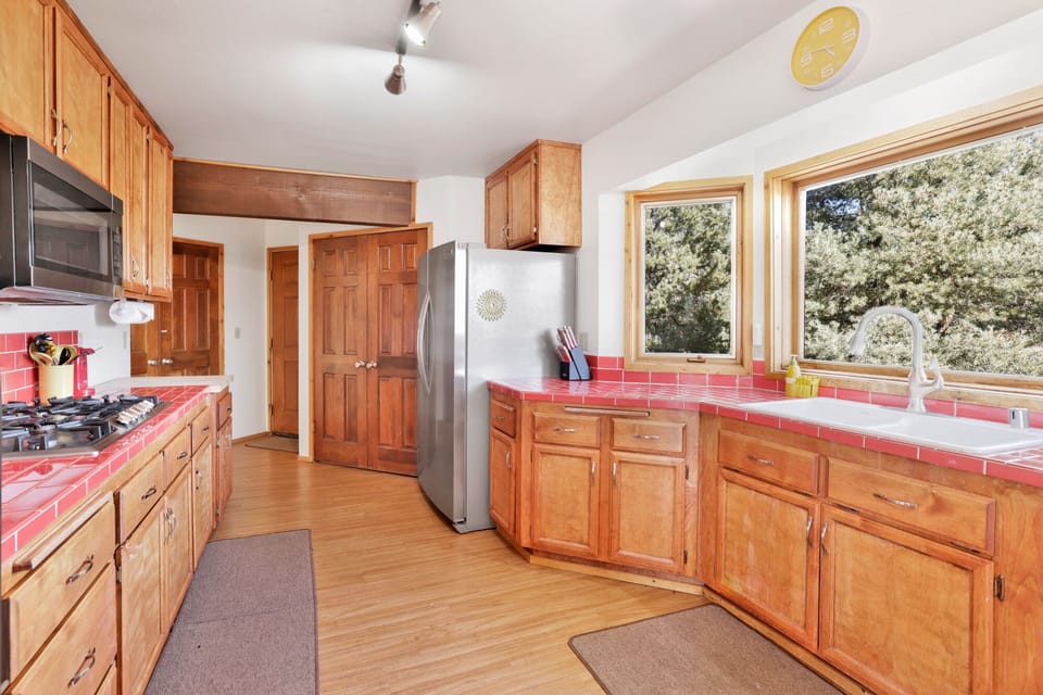 Bright kitchen featuring airy windows, full amenities, and cozy layout perfect for shared meals and gatherings