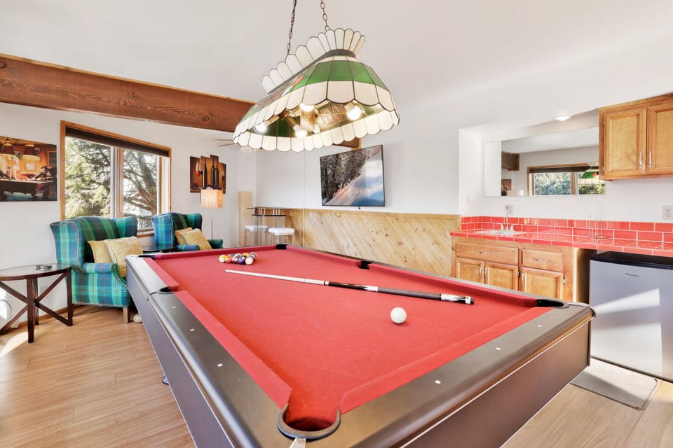 Entertainment room with billiards table and plush sofa, offering fun games and cozy relaxation for guests