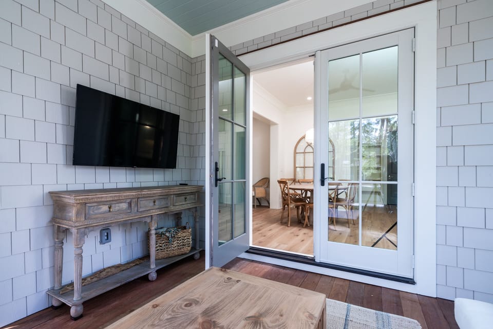 French doors lead from the dining area to the screen porch - wall mounted TV