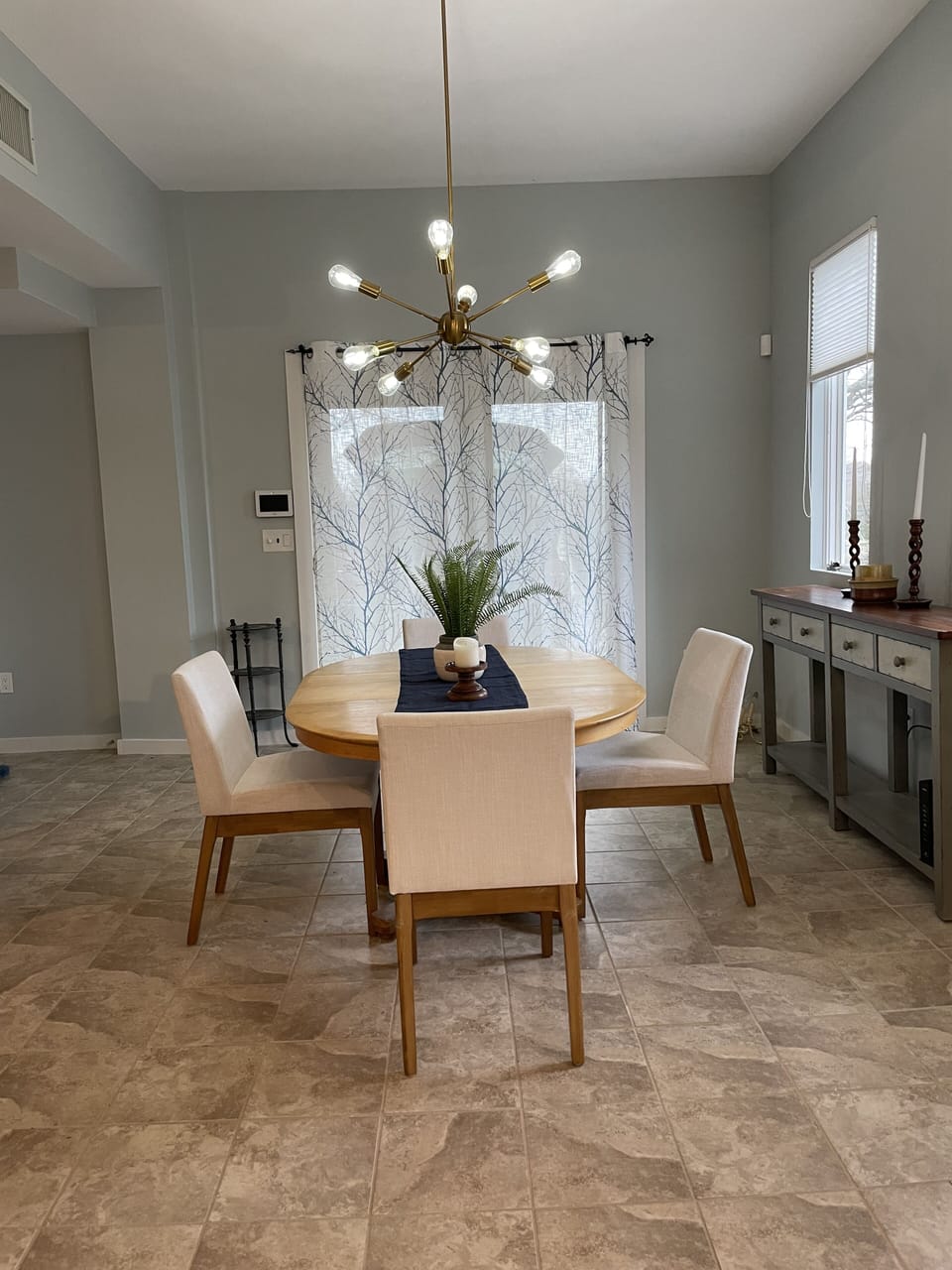 Double doors on the far side of the dining area lead out to the driveway.