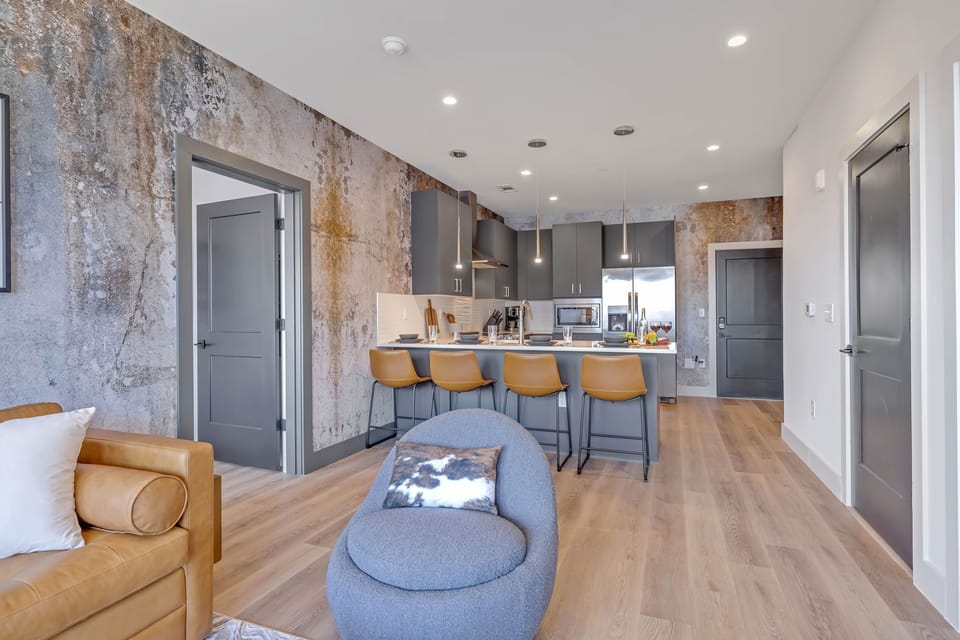 Bright living room with comfortable seating, smart TV, designer decor, and access to the private patio.