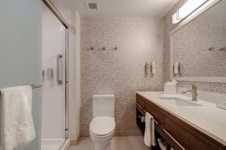 Refresh in a spotless bath with walk-in shower and plush towels.