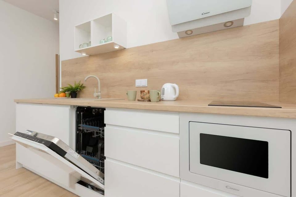 Another angle of the kitchen showing a dining table with chairs and fresh flowers adding vibrancy.
