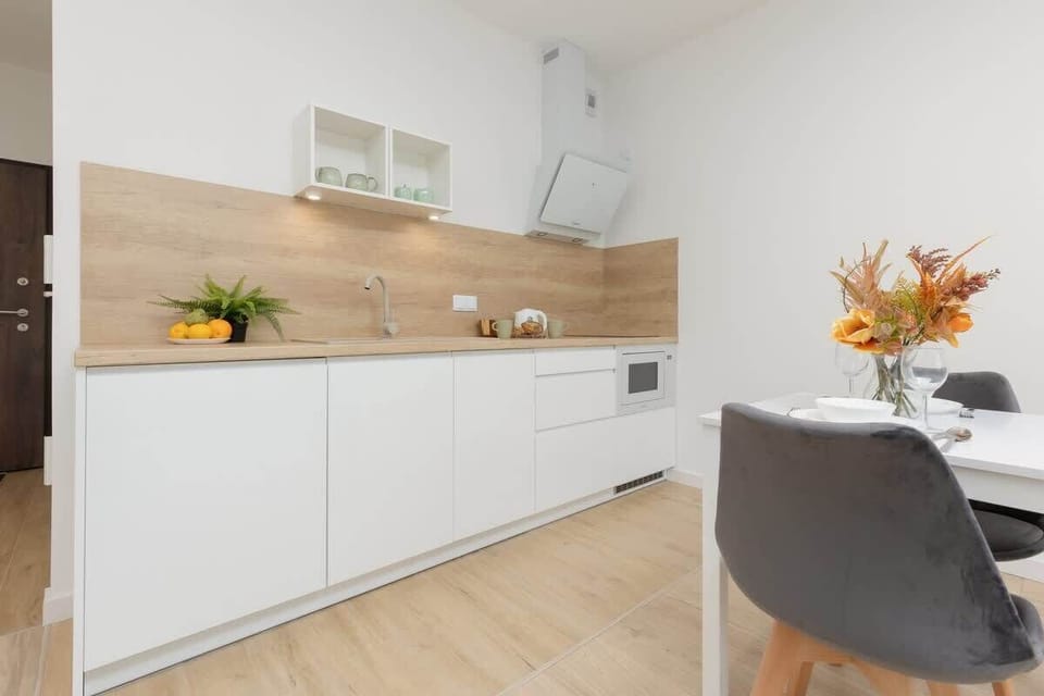 A bright kitchen with white cabinets, wooden countertops, and built-in appliances for a clean, functional design.
