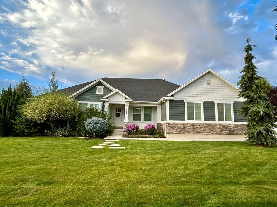 The large grassy mature landscaped front yard of Huckleberry Lane.  Parking on the street for trailers during spring, summer and fall months.