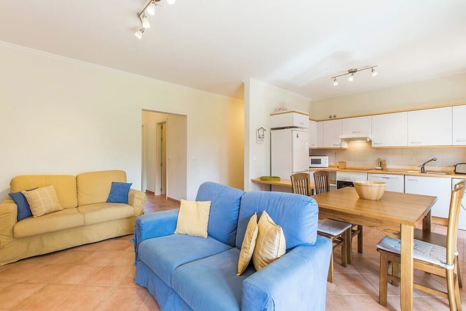 Bright open-plan living room with blue and yellow sofas — Apartment Anibal, holiday apartment in Portugal