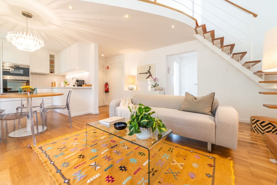 Bright open-plan living room with floating staircase — Apartment Aroeira Golf I, holiday apartment in Portugal