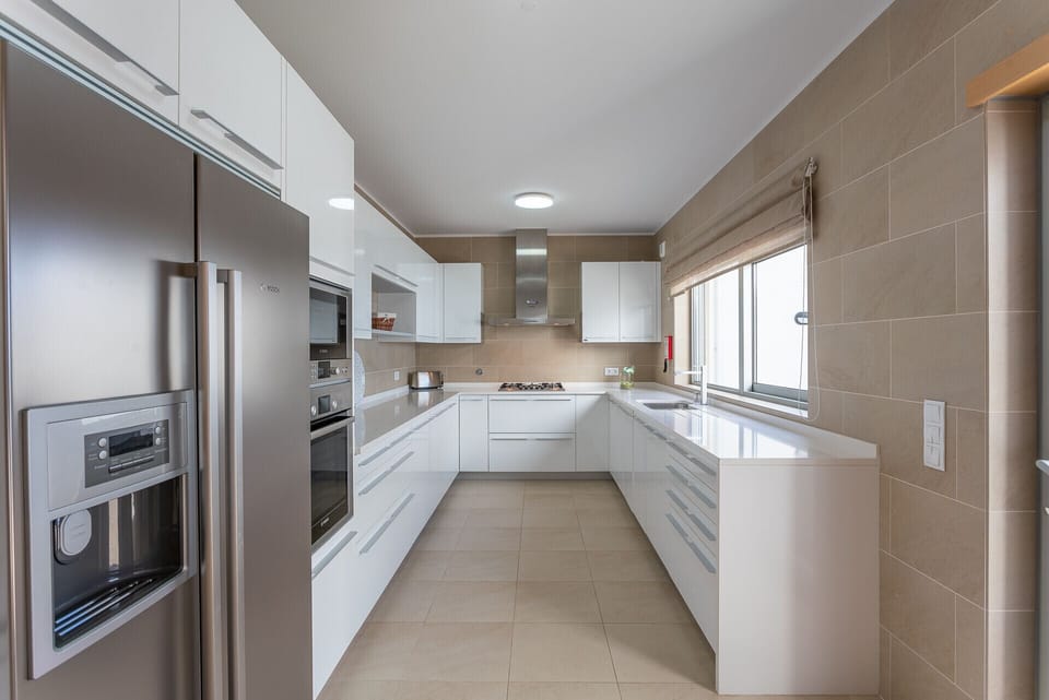 Modern fitted kitchen with white cabinetry and stainless steel appliances — Villa del Rey VIII, holiday villa in Óbidos