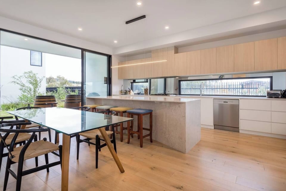 The open-plan dining area includes a six-seater table, with additional seating available at the breakfast bar.
