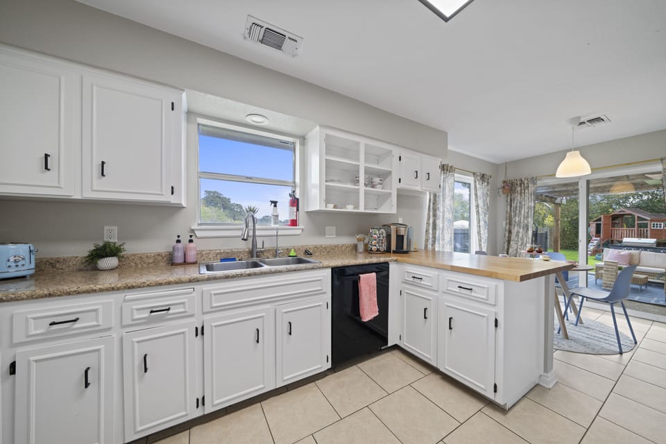 This fully equipped kitchen has a lot of counter tops and has airy vibes