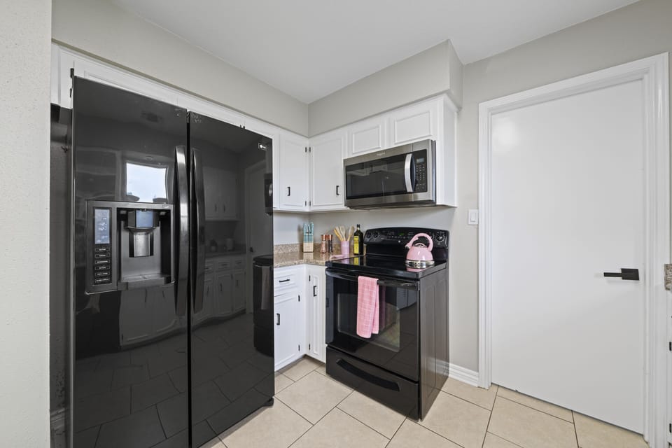 The kitchen has a high-tech refrigerator and a stove with matching color
