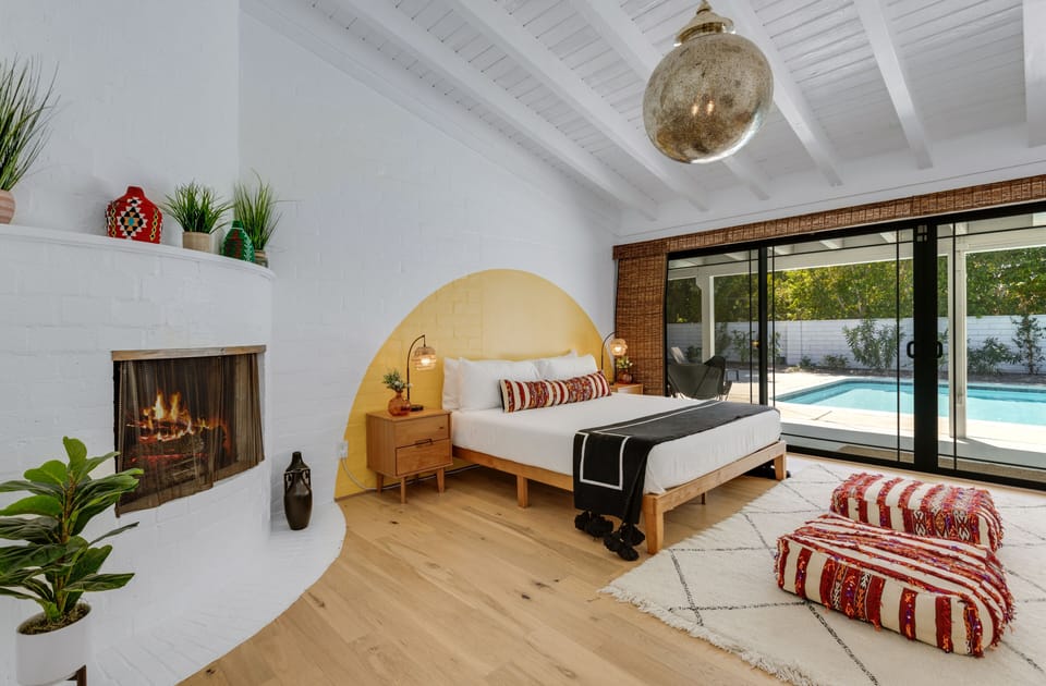Primary king suite with yellow arch, fireplace and pool-facing doors.