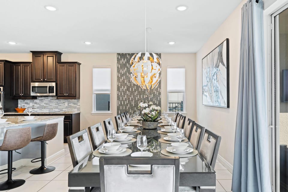 - Elegant dining table with stylish chairs chandelier and bright modern décor  
- Orlando vacation rental dining space perfect for group or family meals daily  
- Shared dining experience creates lasting memories close to Disney attractions