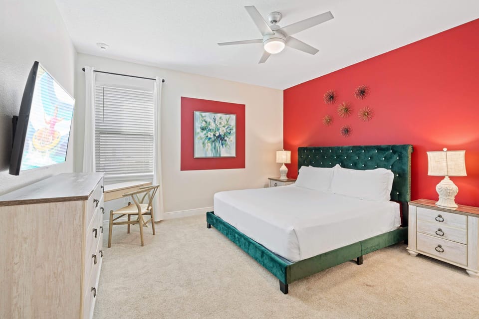 - Bedroom with bold red accent wall green velvet bed and modern décor lighting  
- Orlando vacation rental space perfect for couples or families near Disney stay  
- Stylish furnishings and cozy bedding create restful retreat after adventures