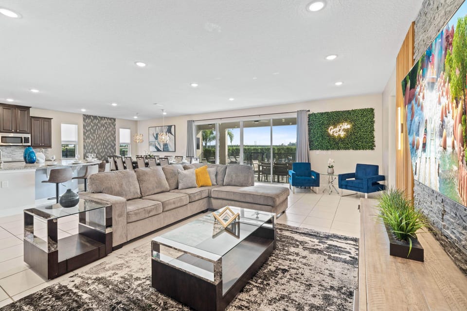 - Open concept living space with sectional seating stylish accents and modern décor  
- Flat screen TV wall and “Good Vibes Only” sign create inviting family comfort  
- Orlando vacation rental perfect for families near Disney and attractions