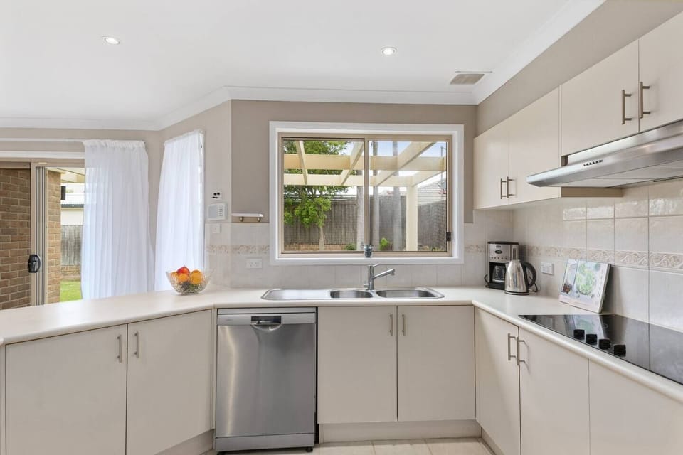 A large, modern kitchen has all you need to cook up a feast, with seating at the breakfast bar and a dishwasher for easy clean-up. 
